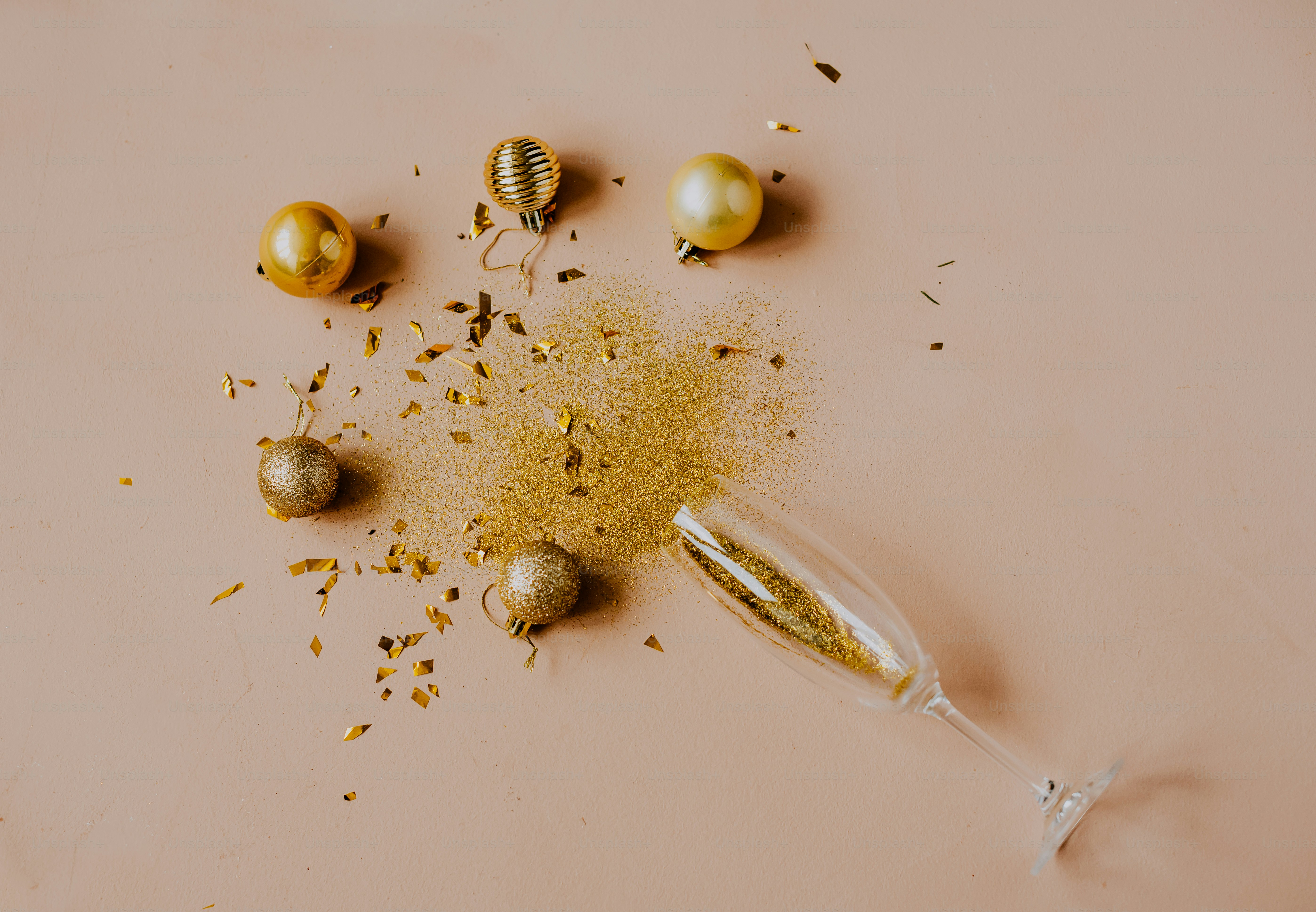 a glass filled with gold glitter next to some ornaments